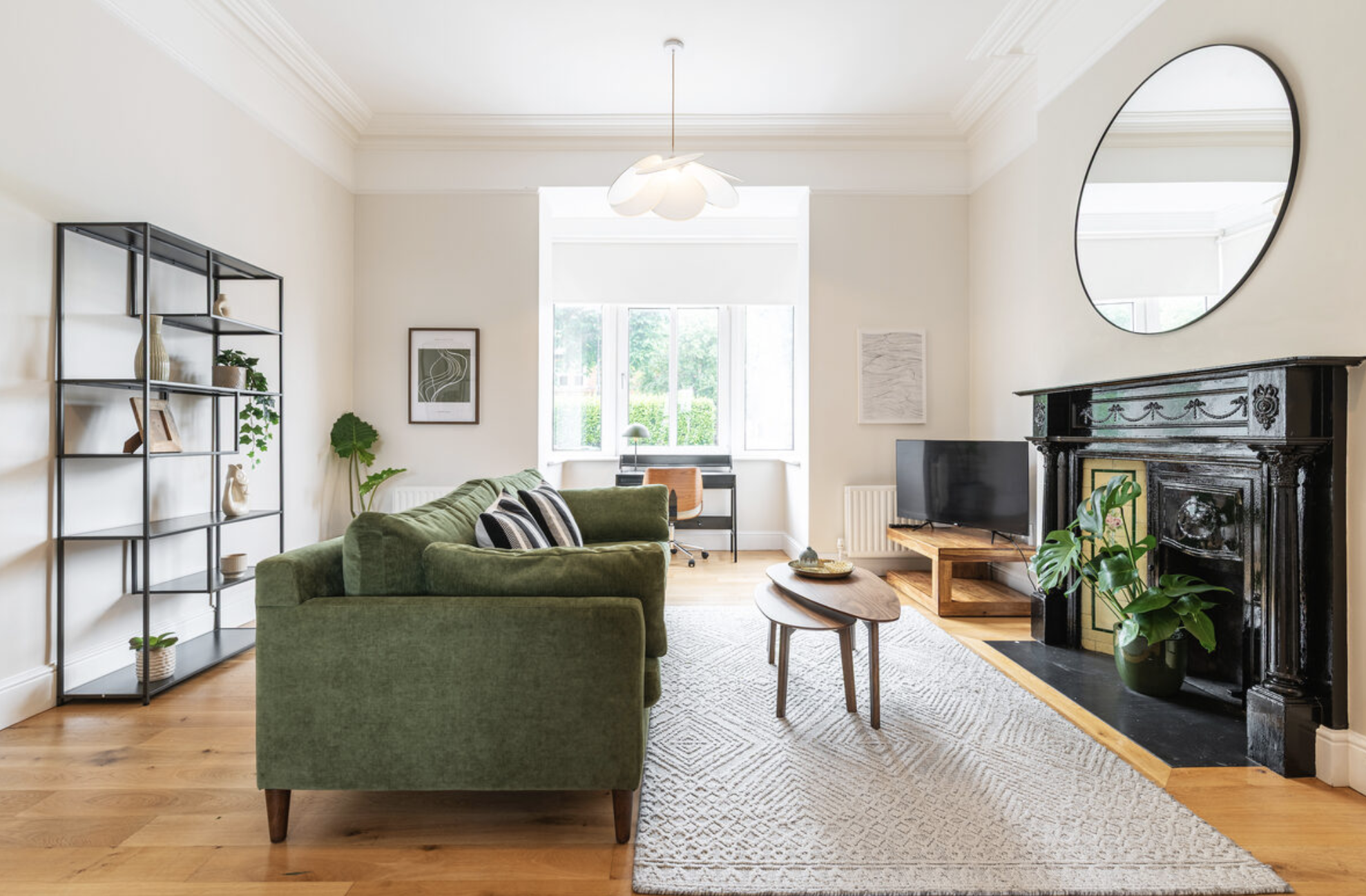 Bright serviced apartment living room with green sofa and Victorian fireplace in Dublin