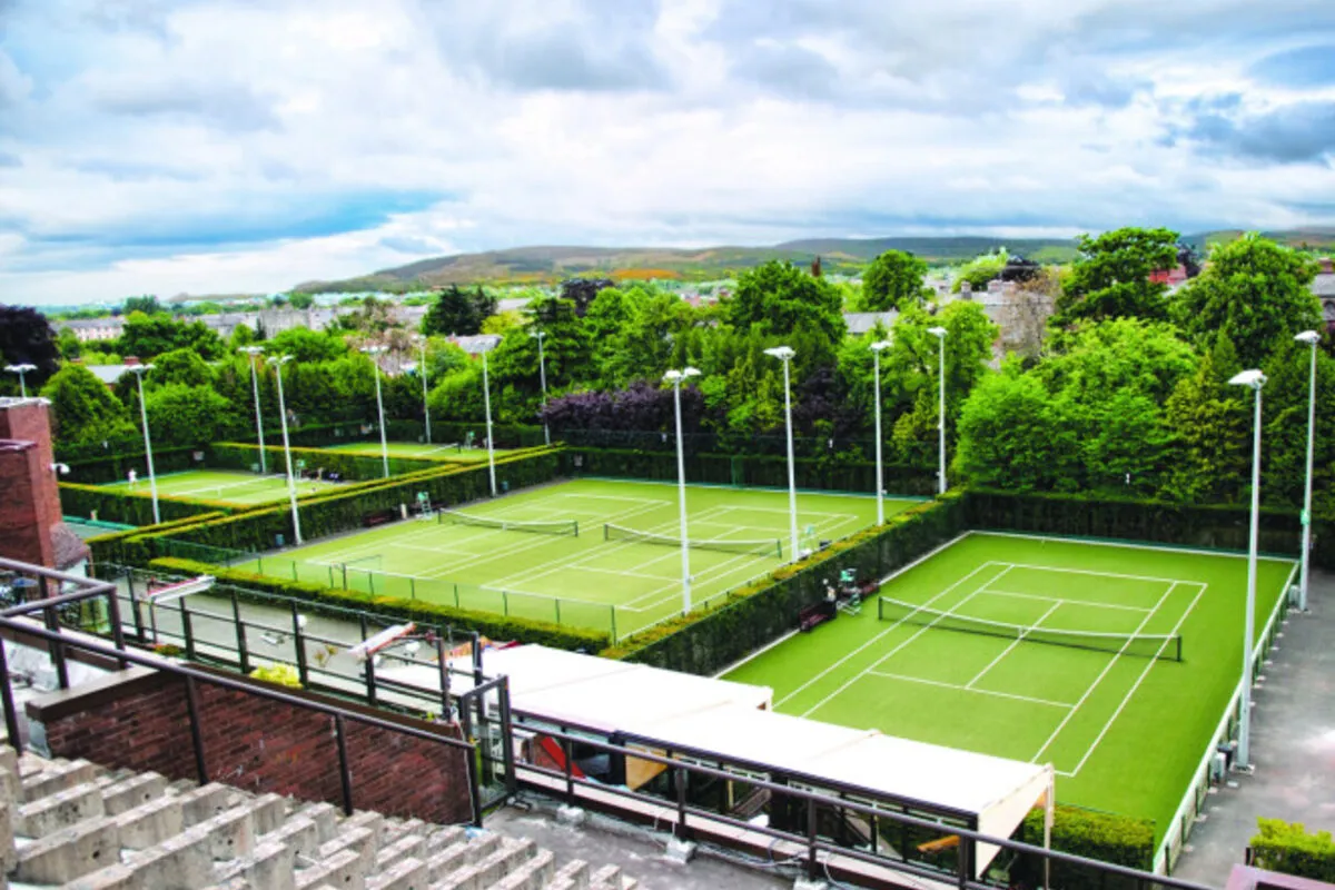 Aerial view of Fitzwilliam Lawn Tennis Club courts, Ranelagh Dublin 6 — floodlit grass and hard courts with Dublin Mountains backdrop, near EirStay serviced apartments