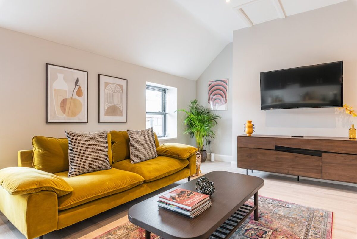 Entertainment area with sofa smart TV and coffee table books in EirStay corporate accommodation Camden Street Dublin 2