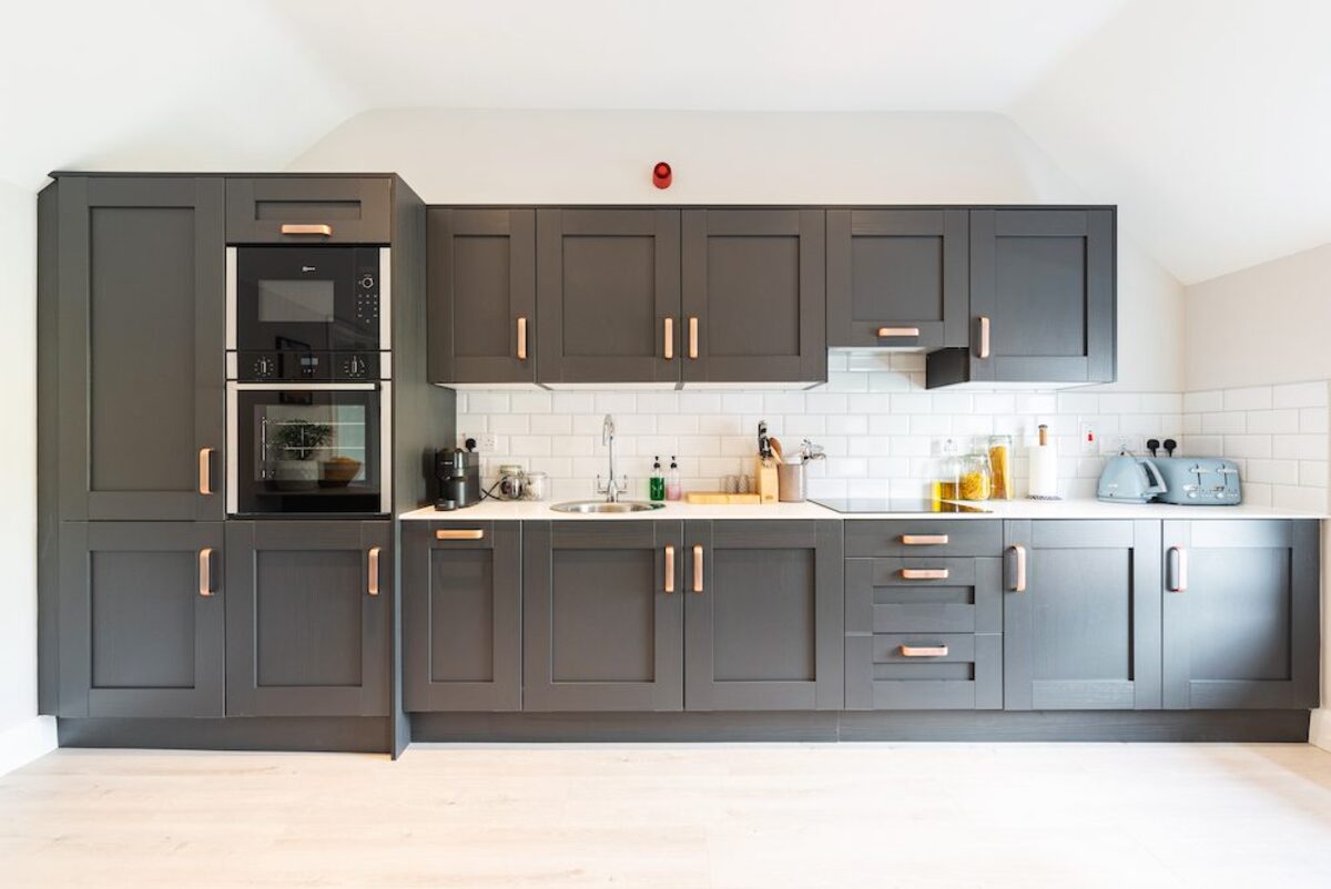 Dark grey shaker kitchen with copper handles metro tile splashback and built-in oven in EirStay corporate short stay Camden Street Dublin 2