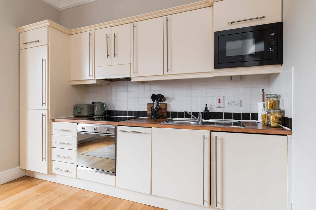 Fitted kitchen with oven microwave and wooden worktops in EirStay corporate short stay apartment Dublin 4