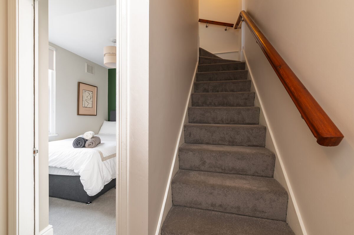 Carpeted staircase and hallway leading to bedrooms in EirStay corporate short stay serviced apartment Dublin 4
