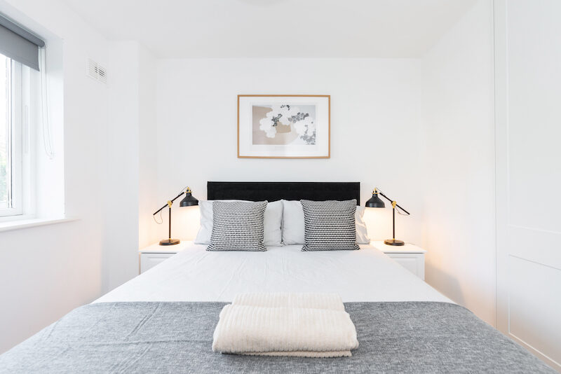Double bedroom with bedside lamps and wardrobe in EirStay Islandbridge one-bedroom serviced apartment Dublin 8