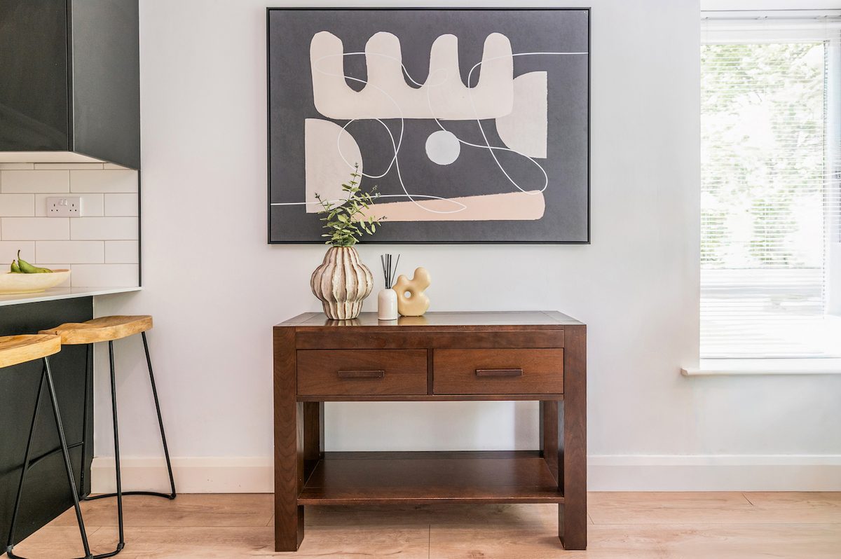 Wooden console table with abstract art and styled decor in EirStay Islandbridge serviced apartment Dublin 8