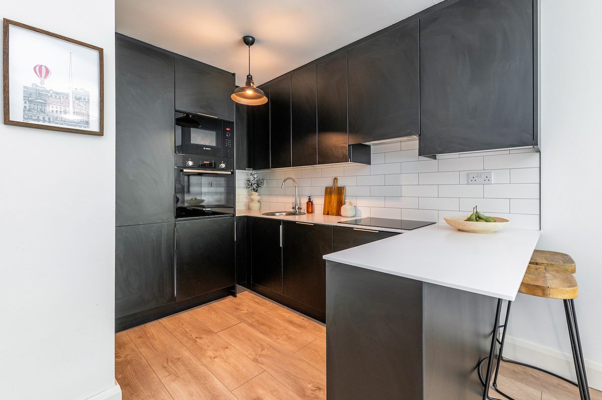 Fully equipped matte-black kitchen with breakfast bar stools and Bosch oven in EirStay Islandbridge serviced apartment Dublin 8