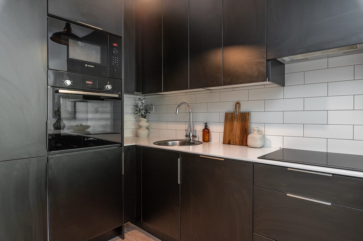 Matte-black kitchen with induction hob, sink and Bosch oven in EirStay Islandbridge corporate apartment Dublin 8