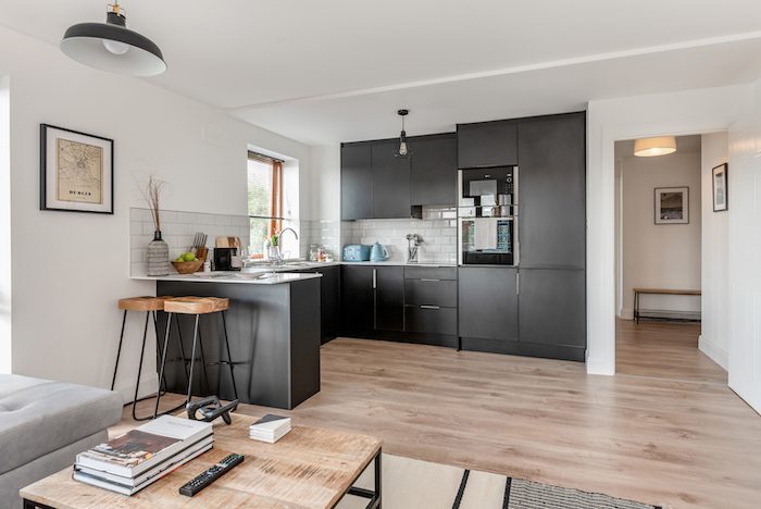 Fitted dark grey kitchen with built-in Neff oven metro tiles and wire pendant light in EirStay serviced apartment Kilmainham Dublin 8