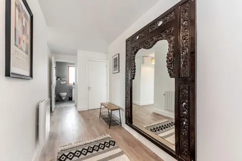 Hallway with ornate carved wooden full-length mirror geometric rug and Paul Klee print in EirStay corporate accommodation Kilmainham Dublin 8