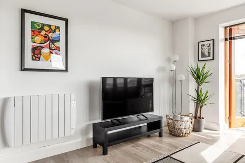 4K Smart TV with colourful art print yucca plant and globe floor lights in EirStay corporate accommodation Kilmainham Dublin 8