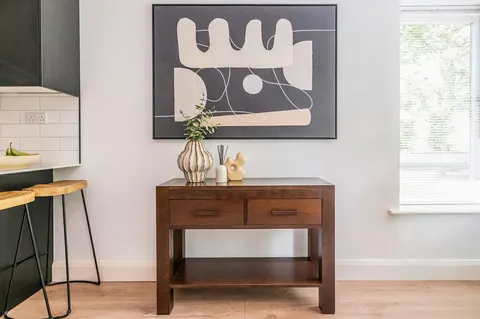 Wooden console table with abstract art and styled decor in EirStay Islandbridge serviced apartment Dublin 8