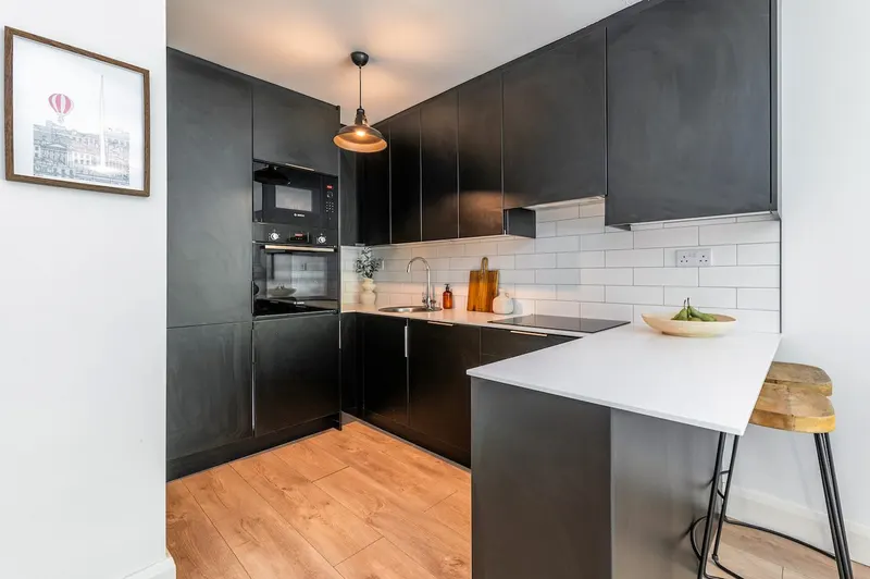Fully equipped matte-black kitchen with breakfast bar stools and Bosch oven in EirStay Islandbridge serviced apartment Dublin 8