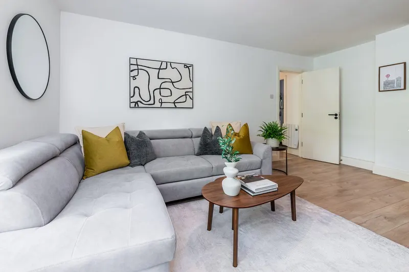 Bright living room with grey corner sofa, wooden coffee table and abstract artwork in EirStay Islandbridge corporate apartment Dublin 8