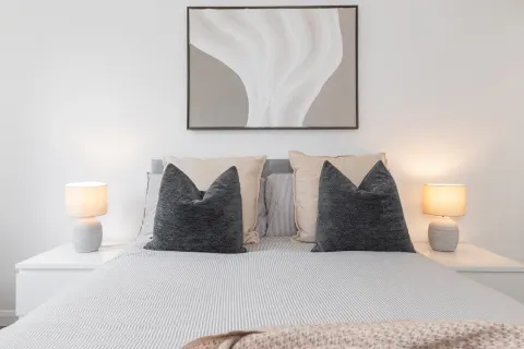 Double bed with cushions, matching bedside lamps and artwork in Rathgar