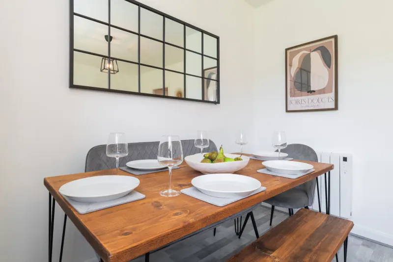 Dining table with bench seating and wall mirror in the Rathgar apartment