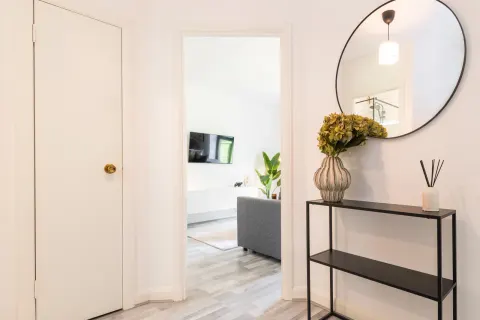 Entrance hallway with round mirror and console table at the Rathgar apartment