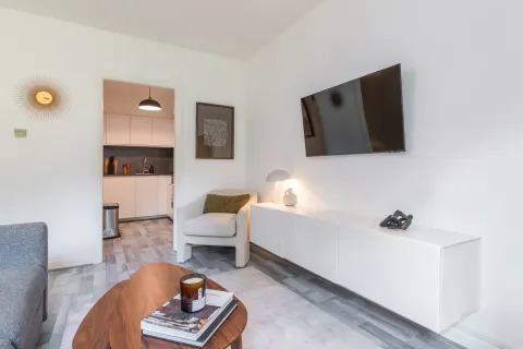 Living room with wall-mounted television and doorway to the kitchen in Rathgar