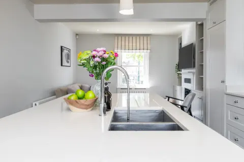 Kitchen island with double sink and open-plan living area at Sandford Gardens