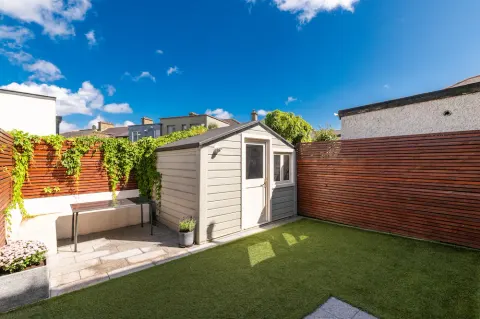 Enclosed garden with a lawn, outdoor seating and a garden shed at Sandford Gardens